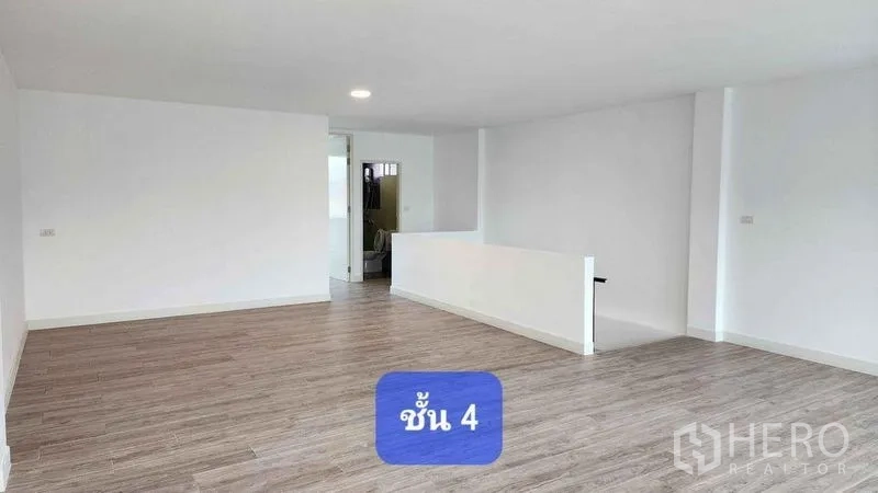 Townhouse for rent in Bueng Kum, Bangkok - Spacious open-plan upper floor with wood-style flooring and a central stairwell.