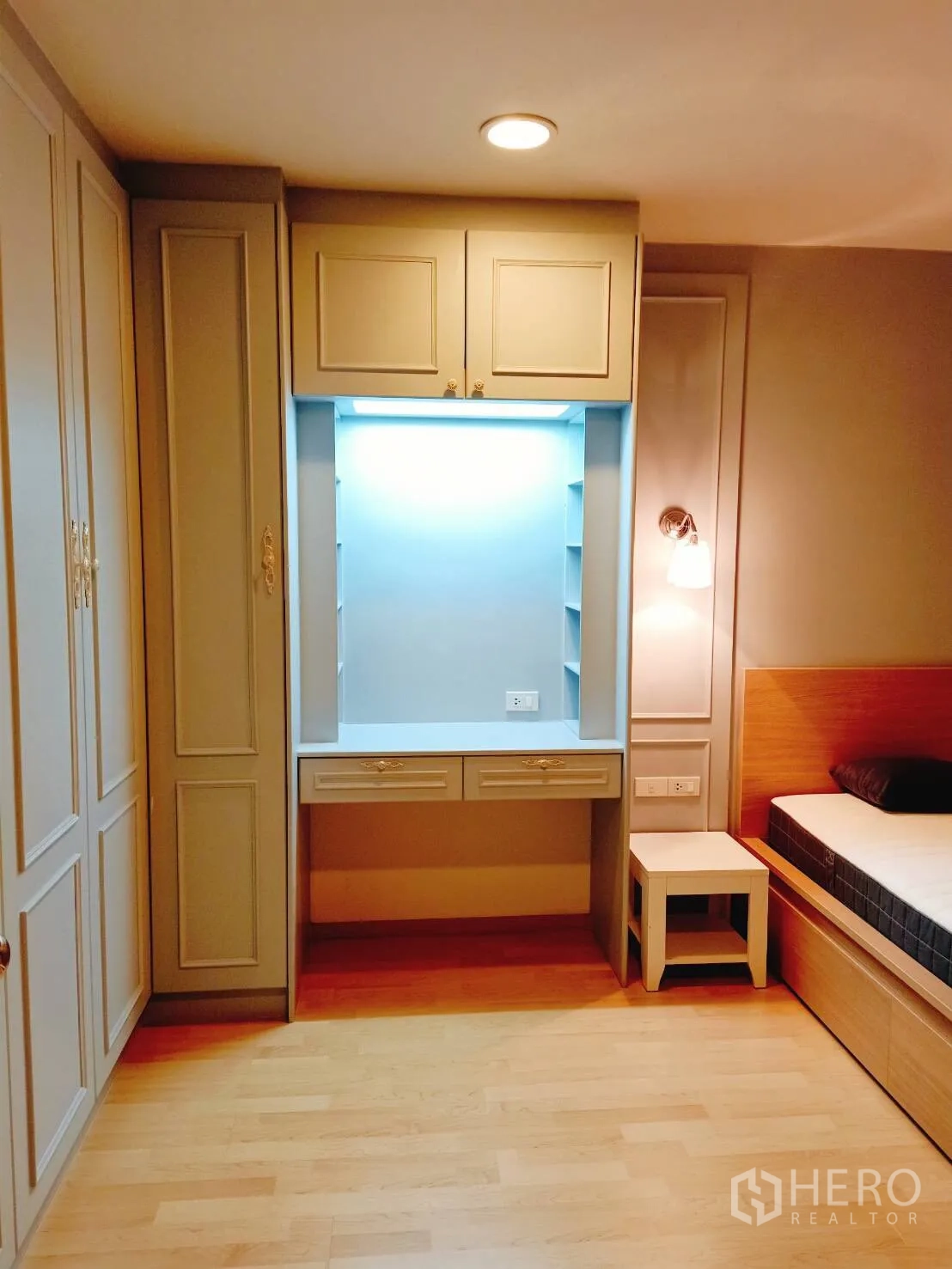 Townhouse for rent in Suan Luang, Bangkok - Built-in dressing nook with illuminated shelves and drawers beside a bedside table