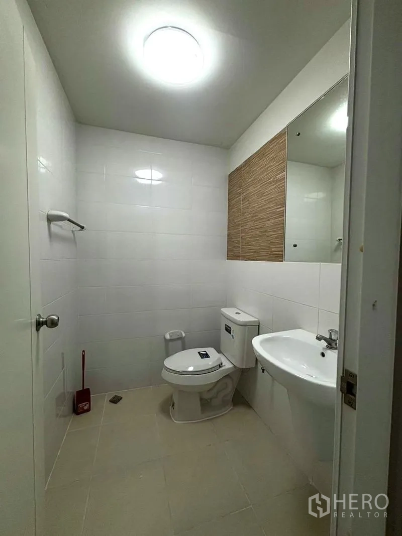 Townhouse for rent in Suan Luang, Bangkok - Guest bathroom with toilet and wall-mounted sink.