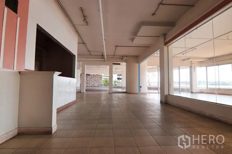 Retail Space for rent in Yan Nawa, Bangkok - Large retail hall with tiled floors, support columns, exposed ceiling conduits, and display window walls.