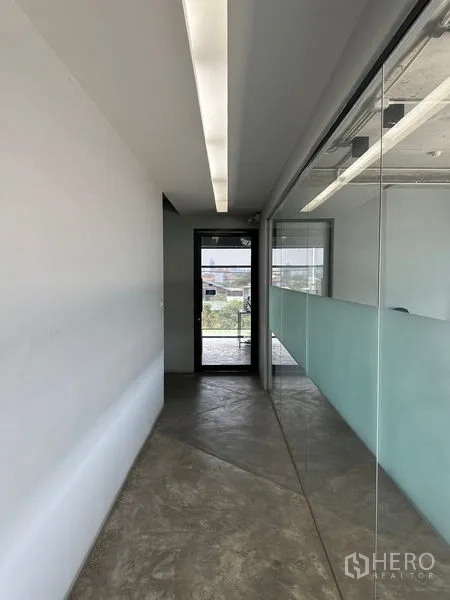 带办公室的家 出租或出售在Prawet, Bangkok - 走廊设嵌灯与玻璃隔断，通往办公间。