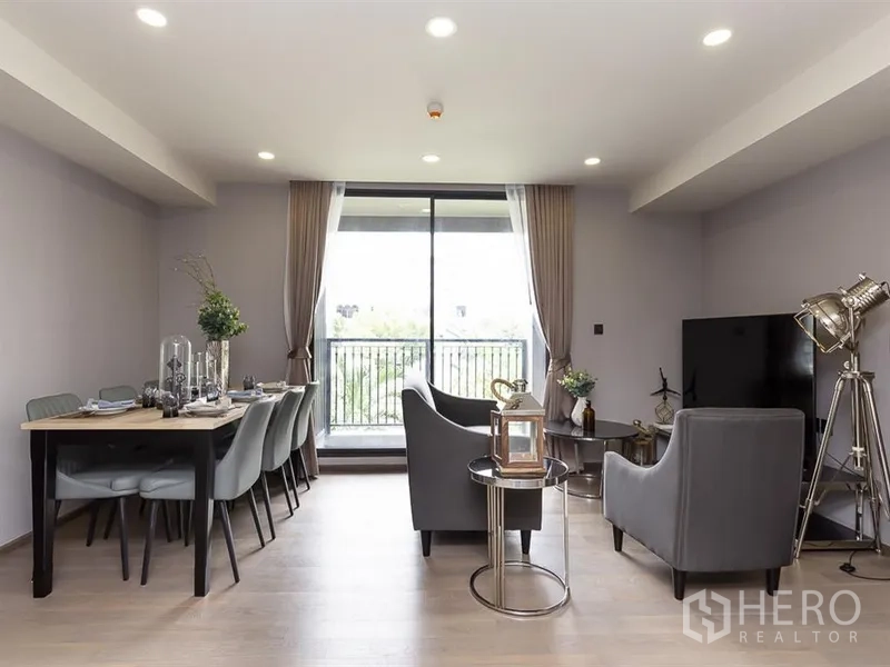 公寓 出租在Pathum Wan, Bangkok - 采光充足的客餐厅，落地移门通往阳台，眺望绿意景观。