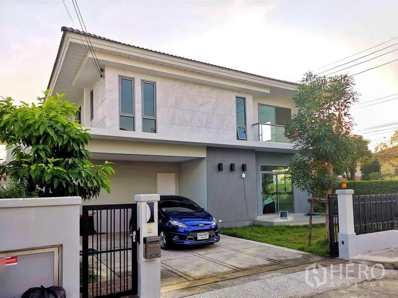 独立式住宅 出售在Nonthaburi - 外立面斜视图，车道大门、遮棚车位与玻璃阳台