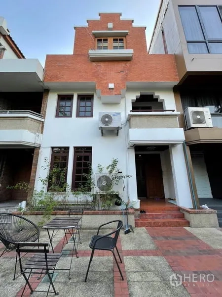 联排别墅 出租在Khlong Toei, Bangkok - 三层联排别墅外立面，红砖与白色外墙，带阳台与台阶入口。
