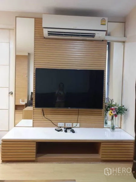 公寓 出租在Watthana, Bangkok - 客厅影音墙，壁挂平板电视、空调与内置矮柜。
