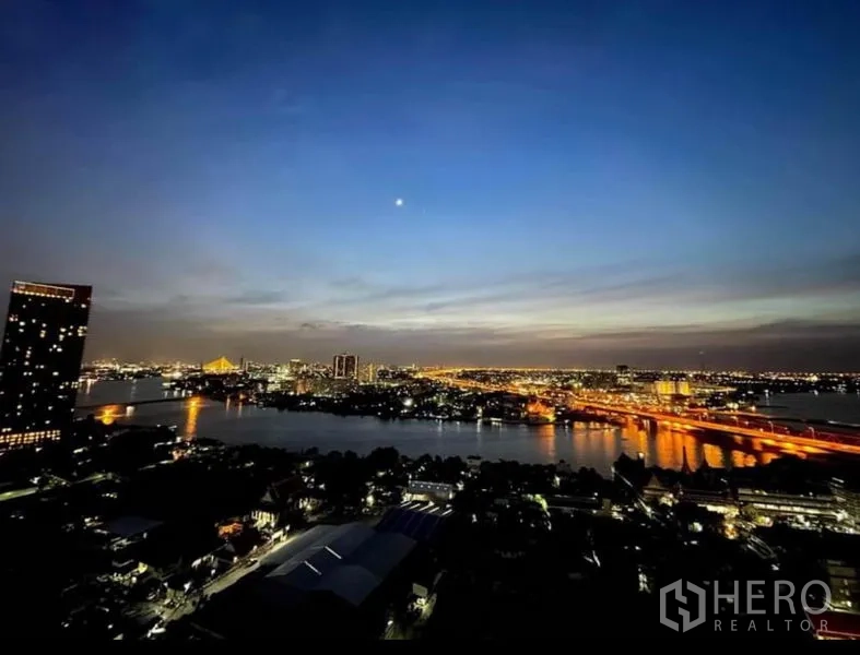 Condominium for sale in Bang Sue, Bangkok - Night panorama of the Chao Phraya River with illuminated bridges and city lights.