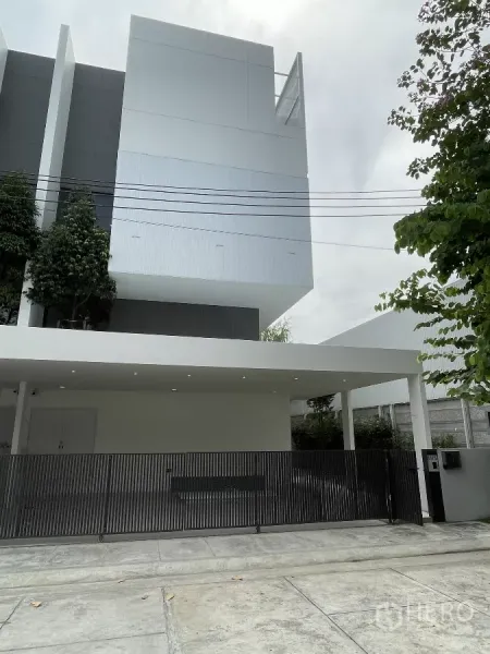 Home Office for rent in Don Mueang, Bangkok - Modern three-story home office facade with carport and black metal gate in Don Mueang.