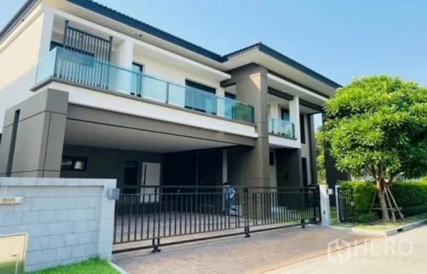 บ้าน ขายในBang Phli, Samut Prakan - บ้านเดี่ยวสองชั้นสมัยใหม่ ระเบียงกระจก โรงจอดรถ และรั้วประตูหน้าบ้าน