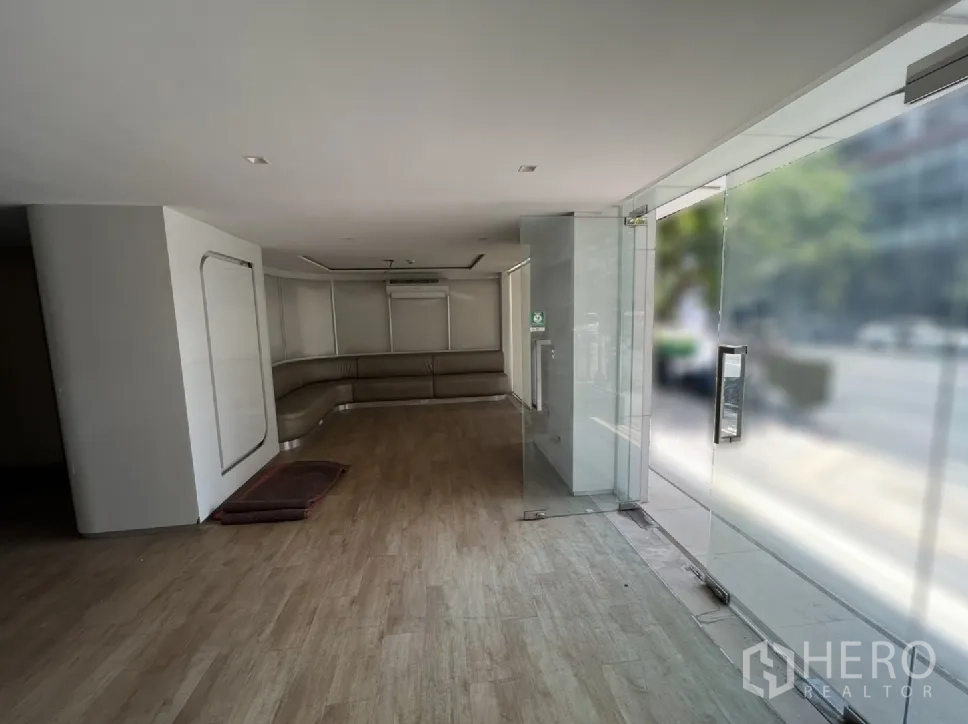 Shophouse for rent or sale in Watthana, Bangkok - Glass-front retail space facing the street with an L-shaped sofa.