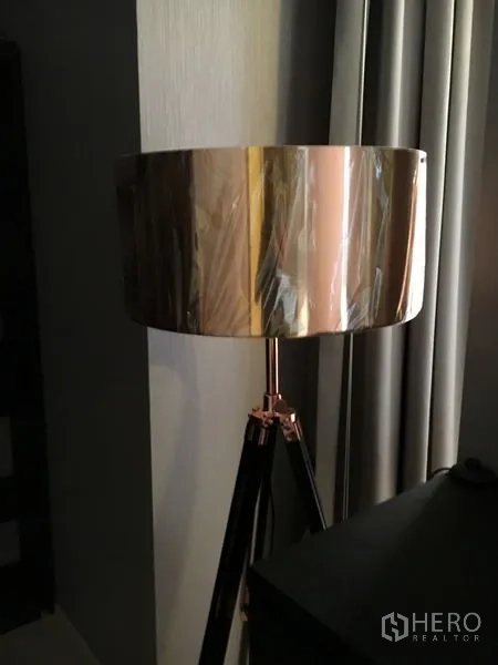 Detached House for rent in Wang Thonglang, Bangkok - Tripod floor lamp with metallic drum shade next to curtains.