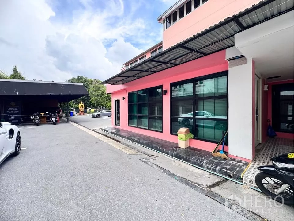 Retail Space for rent in Watthana, Bangkok - Corner exterior of pink low-rise shop building with large windows and on-site parking lane.