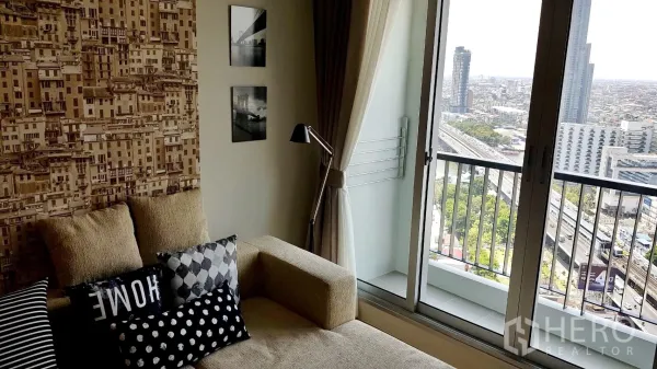 Condominium for rent in Sathon, Bangkok - Living room with sofa and floor lamp opening to a balcony showcasing panoramic Bangkok city views.