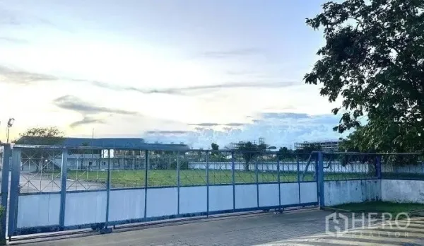 Factory for rent in Bang Bua Thong, Nonthaburi - Secure sliding gate and open compound at an industrial estate in Bang Bua Thong, Nonthaburi.