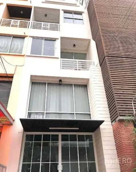 带办公室的家 出租在Wang Thonglang, Bangkok - 街景角度的现代联排式家庭办公楼，落地窗与栏杆阳台。