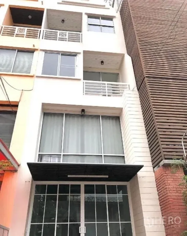 带办公室的家 出租在Wang Thonglang, Bangkok - 街景角度的现代联排式家庭办公楼，落地窗与栏杆阳台。