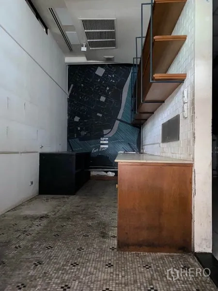 零售空间 出租在Khlong Toei, Bangkok - 店内狭长空间，马赛克地面，木质吧台与壁挂层板，墙面地图装饰。