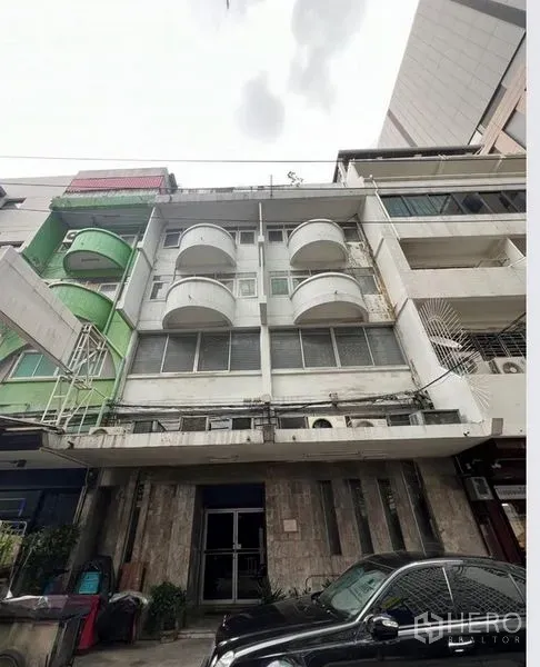 Shophouse for sale - Four-storey shophouse facade with rounded balconies in Silom, Bangkok.