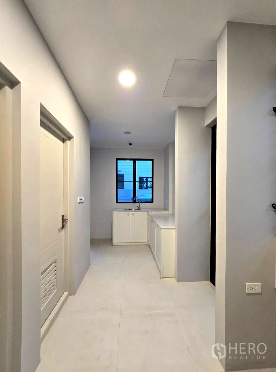 独立式住宅 出租在Saphan Sung, Bangkok - 泰式厨房，燃气灶、水槽与白色橱柜。