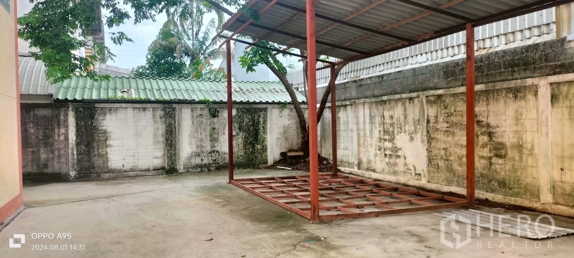 Factory for rent in Khlong Luang, Pathum Thani - Rear yard with steel frame canopy structure beside the boundary wall.