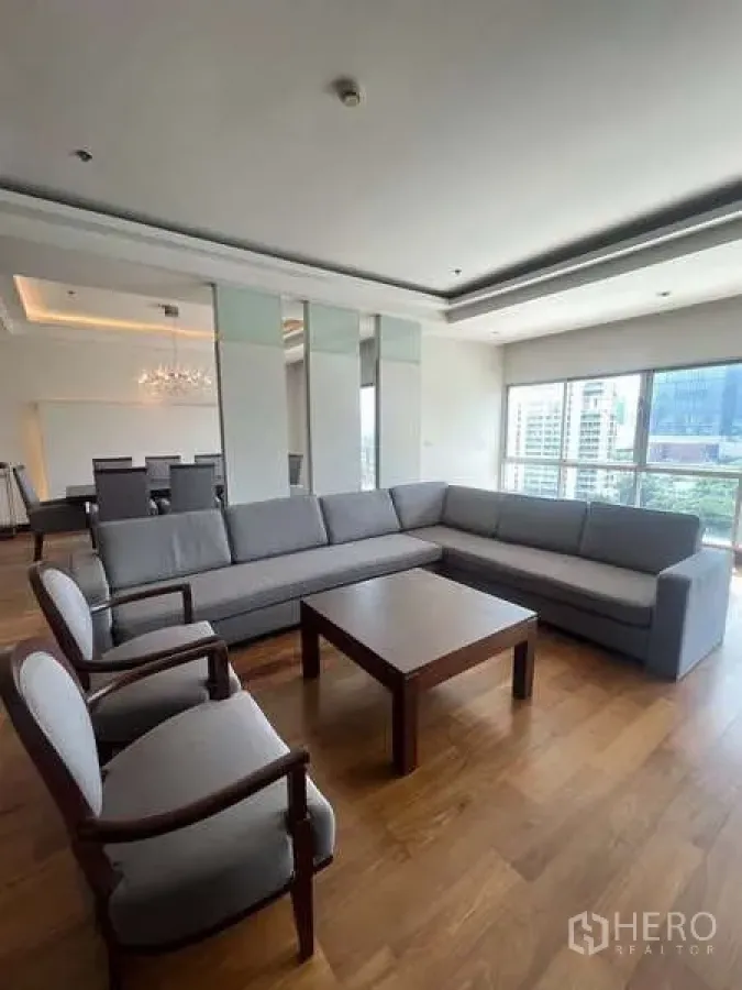房间 出租在Pathum Wan, Bangkok - 客厅另一角度，展示转角沙发、茶几及相邻餐区。