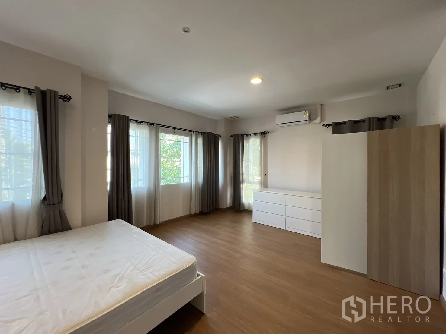 Detached House for rent in Bang Kapi, Bangkok - Large corner bedroom with wood floors and several bright windows.
