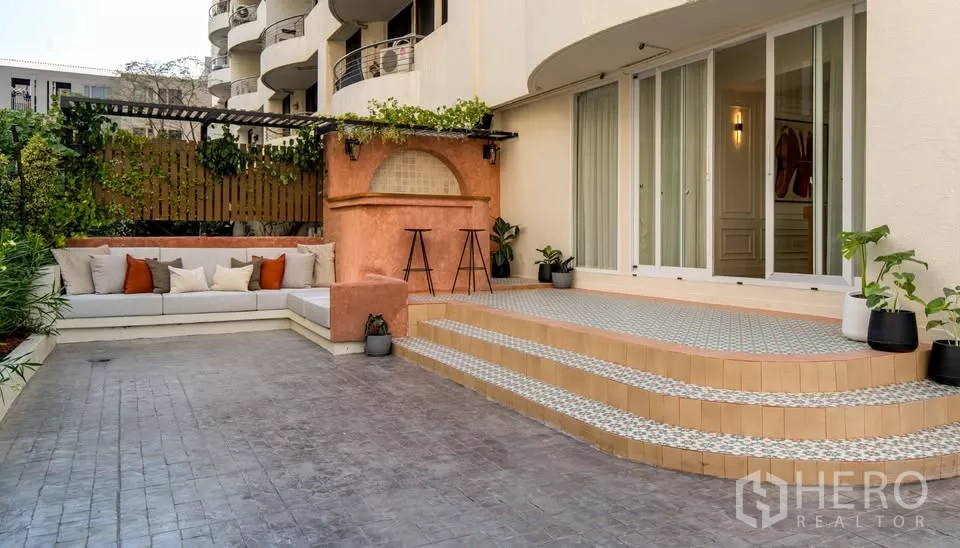 Condominium for sale in Watthana, Bangkok - Outdoor entertaining area at Watthana condominium with built-in sofa, bar counter and sliding doors.