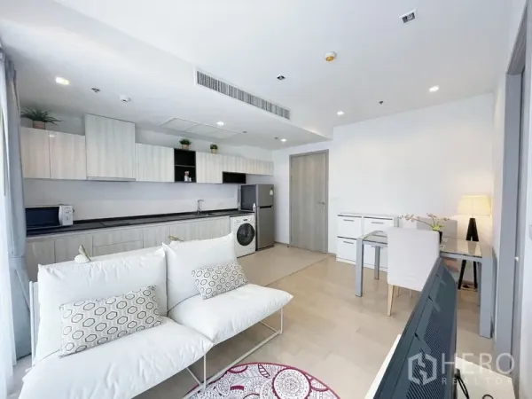 公寓 出售在Watthana, Bangkok - 采光良好的起居区，长形厨房、冰箱与室内洗衣机。