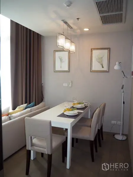 公寓 出租在Ratchathewi, Bangkok - 四人餐区，吊灯、装饰画与落地窗帘营造温馨氛围。