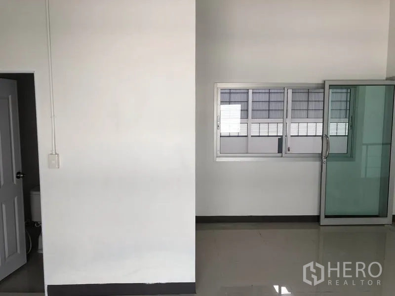 Factory for rent in Phra Nakhon Si Ayutthaya - Clean office corridor with sliding glass door and window inside the factory.