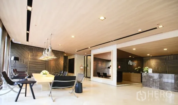 Condominium for rent in Bangkok - Stylish condo lobby with lounge seating, reception desk, and modern lighting.