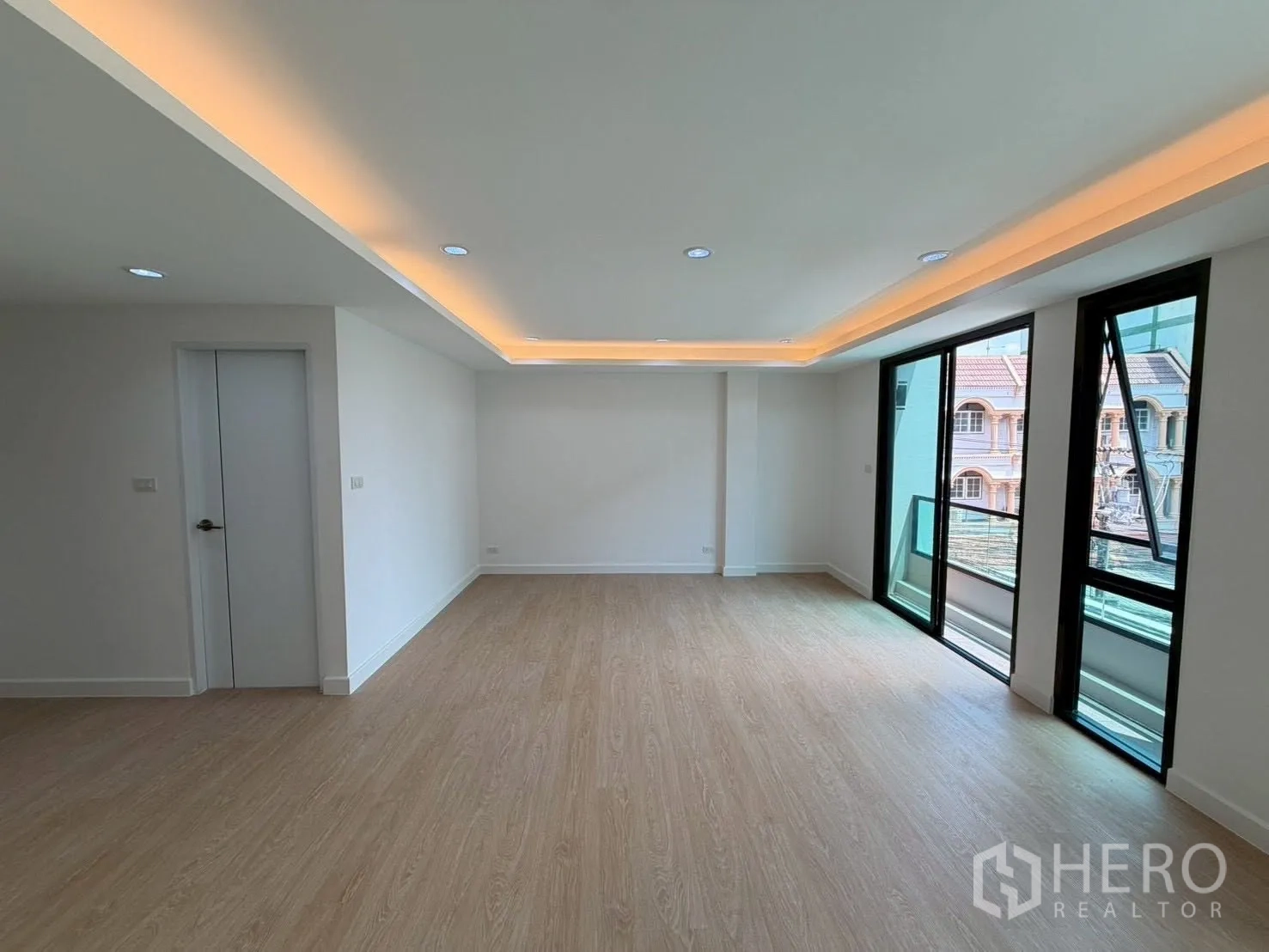 Townhouse for sale in Phra Khanong, Bangkok - Large room with sliding doors to a small balcony and neighborhood views.
