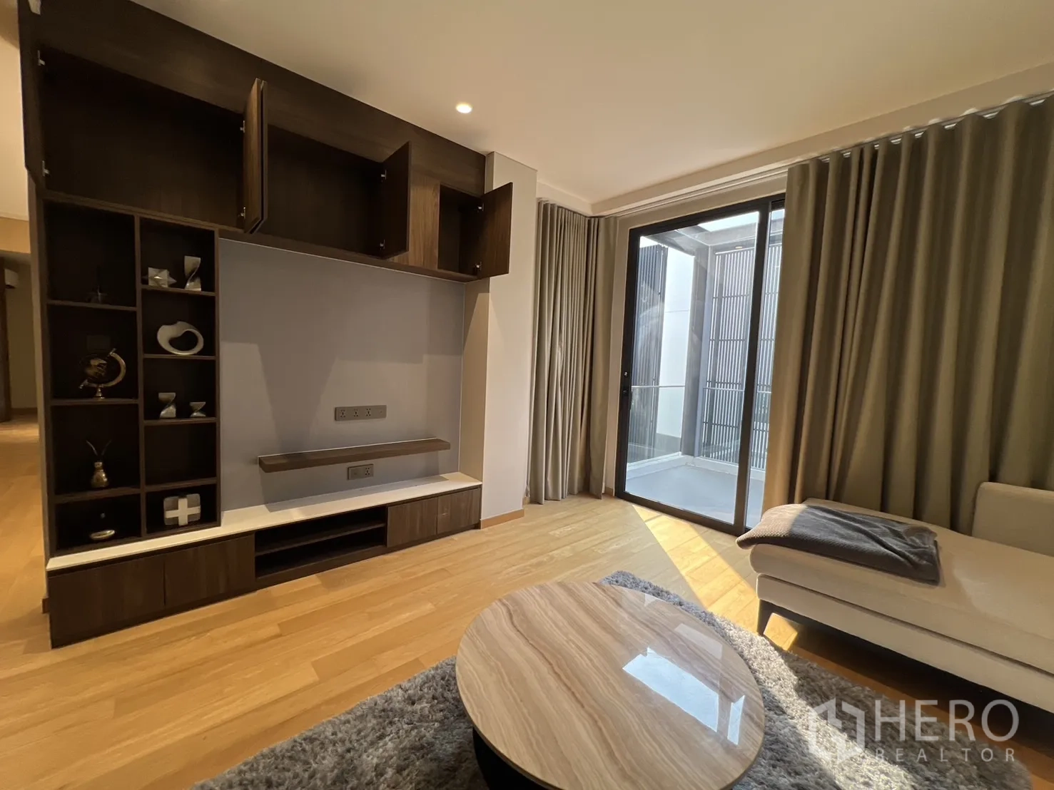 Detached House for rent in Suan Luang, Bangkok - Upper lounge with built‑in media wall and sliding door to balcony.