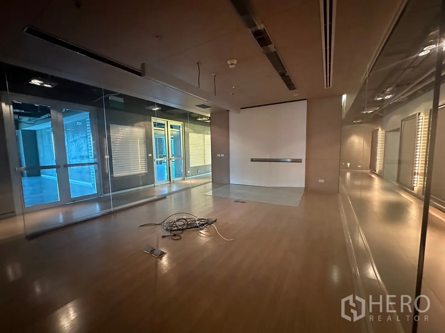 Office Space for rent in Khlong Toei, Bangkok - Glass-walled meeting or showroom space with wooden flooring.