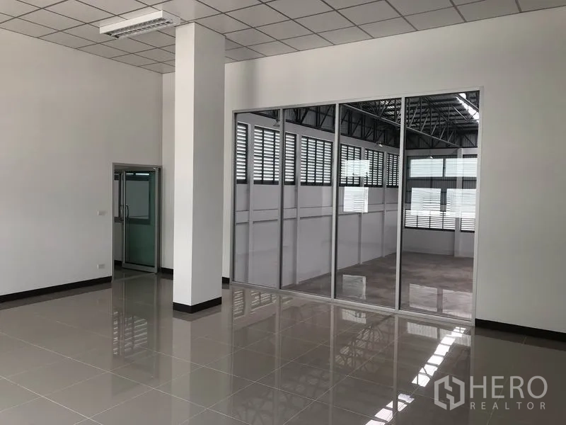 Factory for rent in Phra Nakhon Si Ayutthaya - Bright office room with grid ceiling and large glass partition to the warehouse.