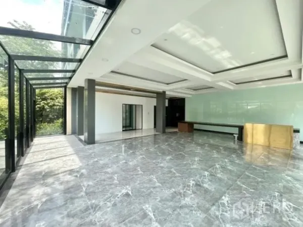 Detached House for rent or sale in Khlong Toei, Bangkok - Spacious ground-floor hall with marble flooring, coffered ceilings and a glass pavilion opening to the garden.