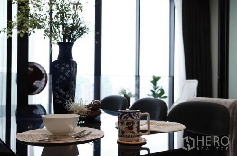 公寓 出租 - 餐桌特写，摆放花瓶与餐具，靠窗景致优美。