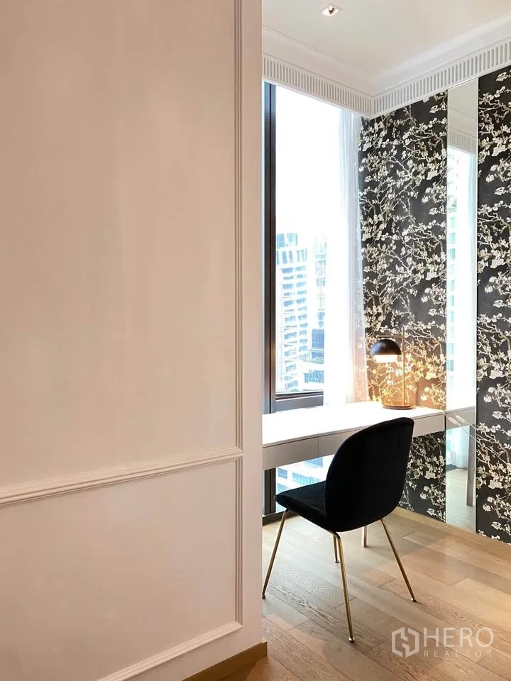 公寓 for rent in Pathum Wan, Bangkok - 窗边书桌配黑色椅与台灯，花纹墙面与高窗带来明亮城市景观。