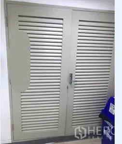 Office Space for rent in Khlong Toei, Bangkok - Louvered utility doors in the corridor with a nearby recycling bin.