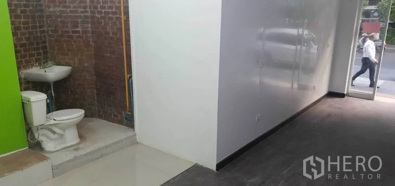 Retail Space for rent in Khlong Toei, Bangkok - Shop corner showing brick feature wall with sink and toilet beside the sales area.