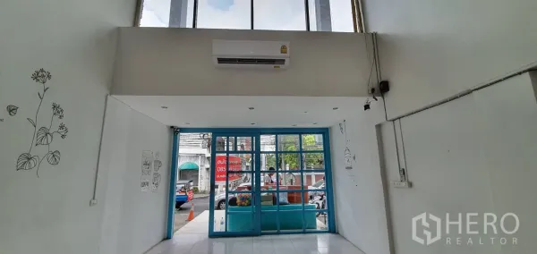 带办公室的家 出租在Khlong Toei, Bangkok - 挑高入口，蓝色玻璃门，白色墙面与简约线条壁画。