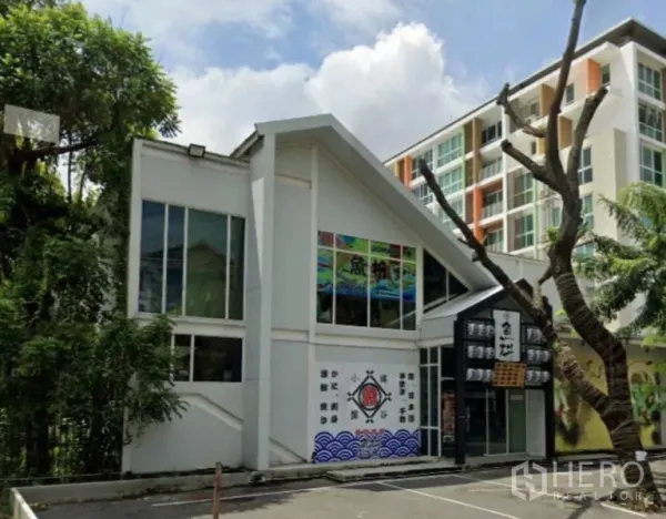 Retail Space for rent in Watthana, Bangkok - Front exterior of a two-storey standalone retail building with large windows and on-site parking.