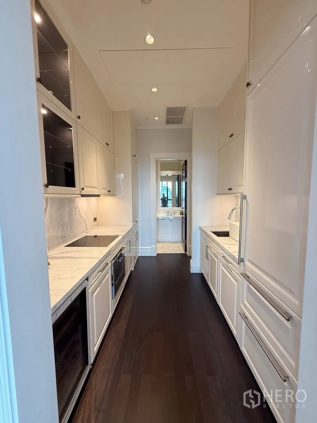 คอนโด for rent or sale in Pathum Wan, Bangkok - ครัวแบบแกลลีย์ยาว ตู้บิลท์อินสีขาว เคาน์เตอร์หินอ่อน และเครื่องใช้ไฟฟ้าบิวท์อิน