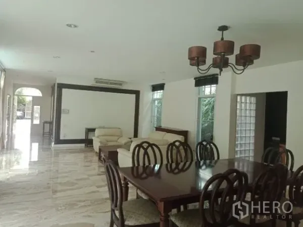 Detached House for rent in Bang Rak, Bangkok - Open-plan living and dining room with marble floors, large windows and a classic chandelier.