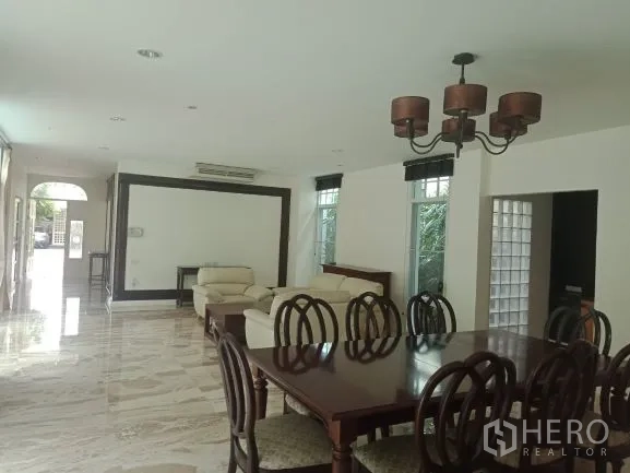 Detached House for rent in Bang Rak, Bangkok - Open-plan living and dining room with marble floors, large windows and a classic chandelier.