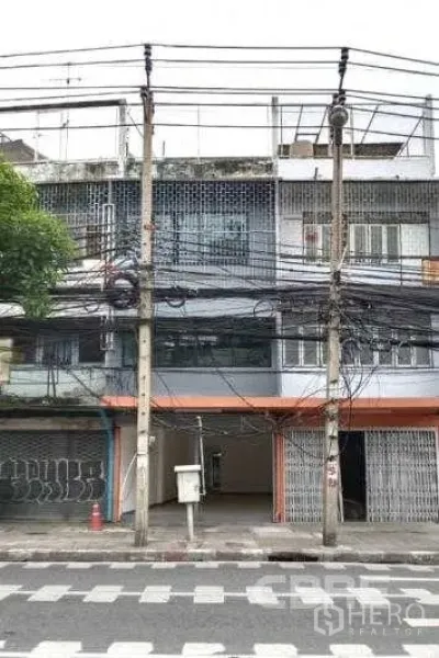 อาคารพาณิชย์ ขายในKhlong Toei, Bangkok - อาคารพาณิชย์หลายชั้นติดถนนในเขตคลองเตย กรุงเทพฯ หน้ากว้าง มีประตูม้วนโลหะ ช่องจอดรถด้านหน้า และสายไฟเหนือศีรษะ