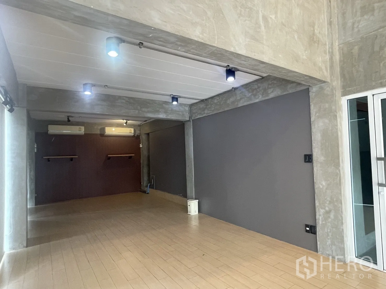 带办公室的家 出租在Suan Luang, Bangkok - 开放式工作室，轨道灯、灰色特色墙与木纹地板。