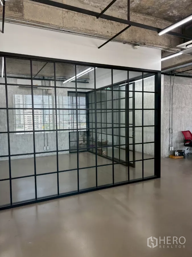 办公空间 出租在Watthana, Bangkok - 玻璃会议室转角视图，明亮窗户与城市景色及条形照明。