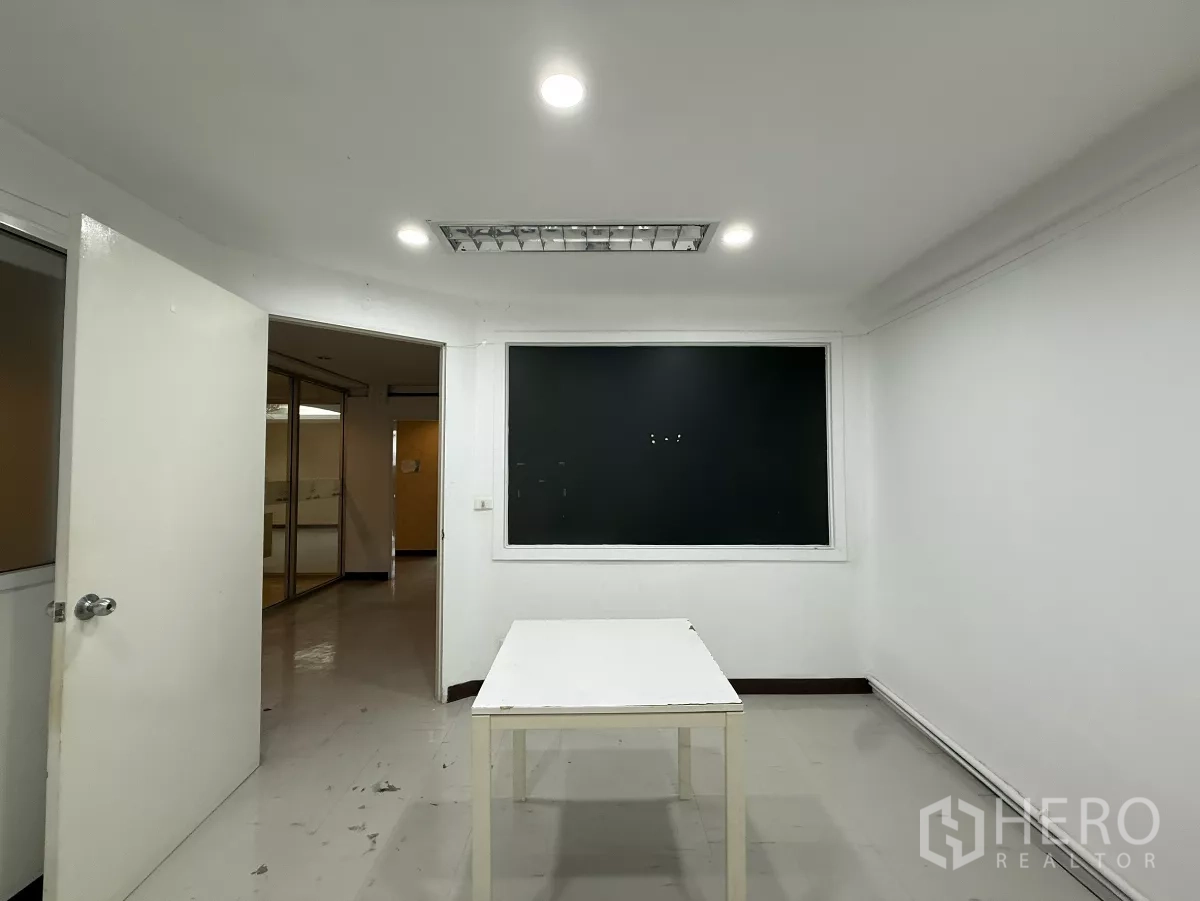 办公空间 出租在Din Daeng, Bangkok - 白色会议室，中间摆放桌子，顶灯明亮，配内窗。