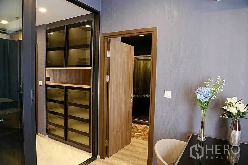 公寓 出租在Huai Khwang, Bangkok - 入口区设陈列柜与通往卧室的门，并以花瓶装饰。