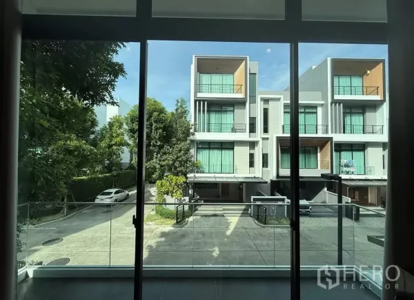 Townhouse for rent in Saphan Sung, Bangkok - View from the balcony over a quiet internal road and contemporary townhomes shaded by trees.